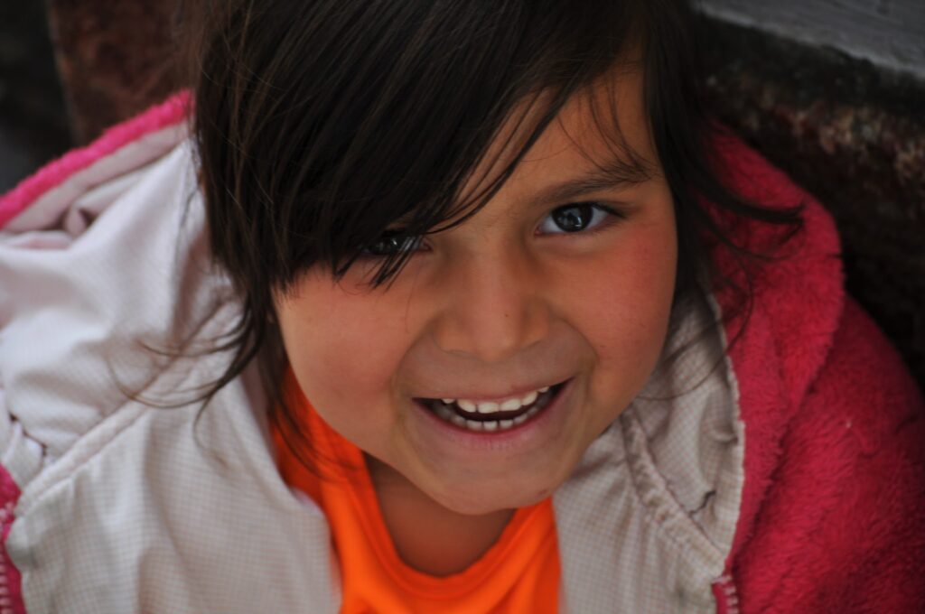 Little Ecuadorian girl showing off her beautiful smile to the camera in Cuenca, Ecuador.